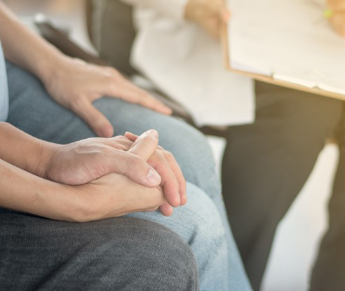 Two people holding hands in therapy session. This image could depict a family who is looking for help with behavior or substance addiction. Both can be helped with an addiction counseling in North Carolina today. Get started! 28401 | 28402 | 28403 