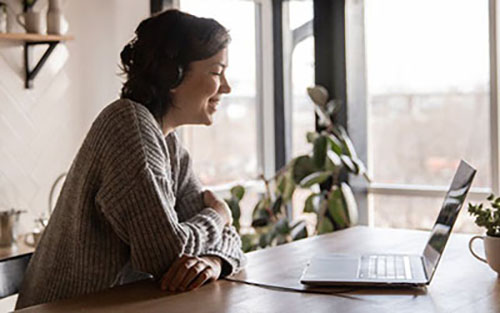 Image of person on laptop smiling. This image could depict someone who is receiving online therapy in North Carolina. You could also start with an online therapist in north Carolina, too! 28374 | 28403 | 27705