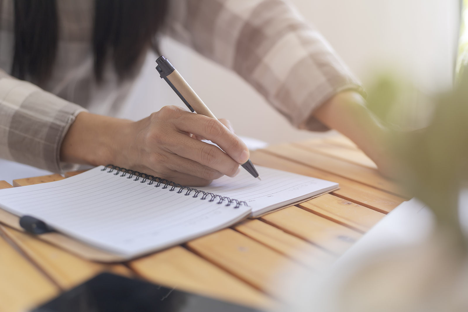 Image of person writing. This image could depict someone who is improving their mental wellness in North Carolina with journaling. Start therapy with an online therapist in north Carolina to begin your mental wellness journey! 28562 | 25015 | 27513
