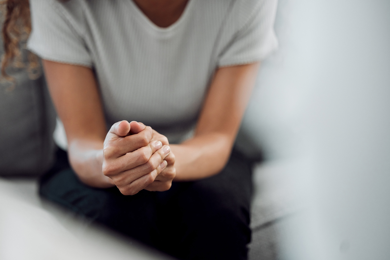 A close up of a person sitting on a couch. This could represent trauma therapy in New Bern, NC. Learn more about online trauma therapy in New Bern, NC by contacting a trauma therapist in New Bern, NC today. 