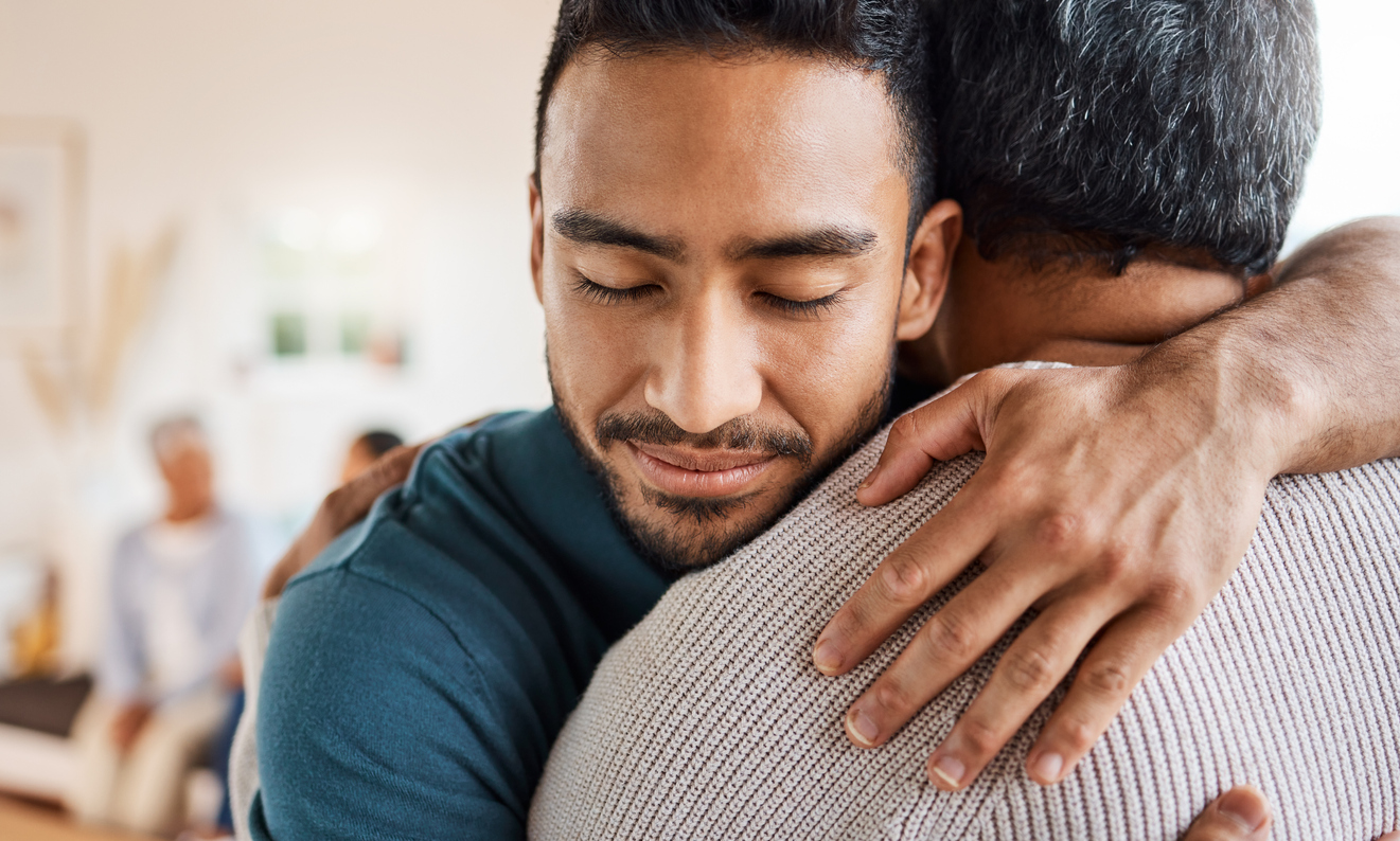 A man hugs their father with a smile on their face. This could represent the support trauma therapy in New Bern, NC can offer. Learn more about online trauma therapy in North Carolina by contacting a trauma therapist in New Bern, NC today.