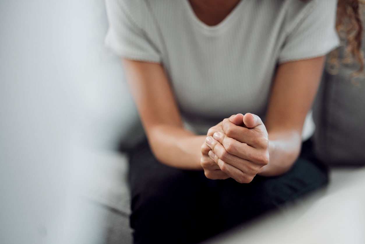 Hands on knees, looking intense during a trauma therapy session in North Carolina Via online therapy. Find your online trauma therapist in North Carolina here. 