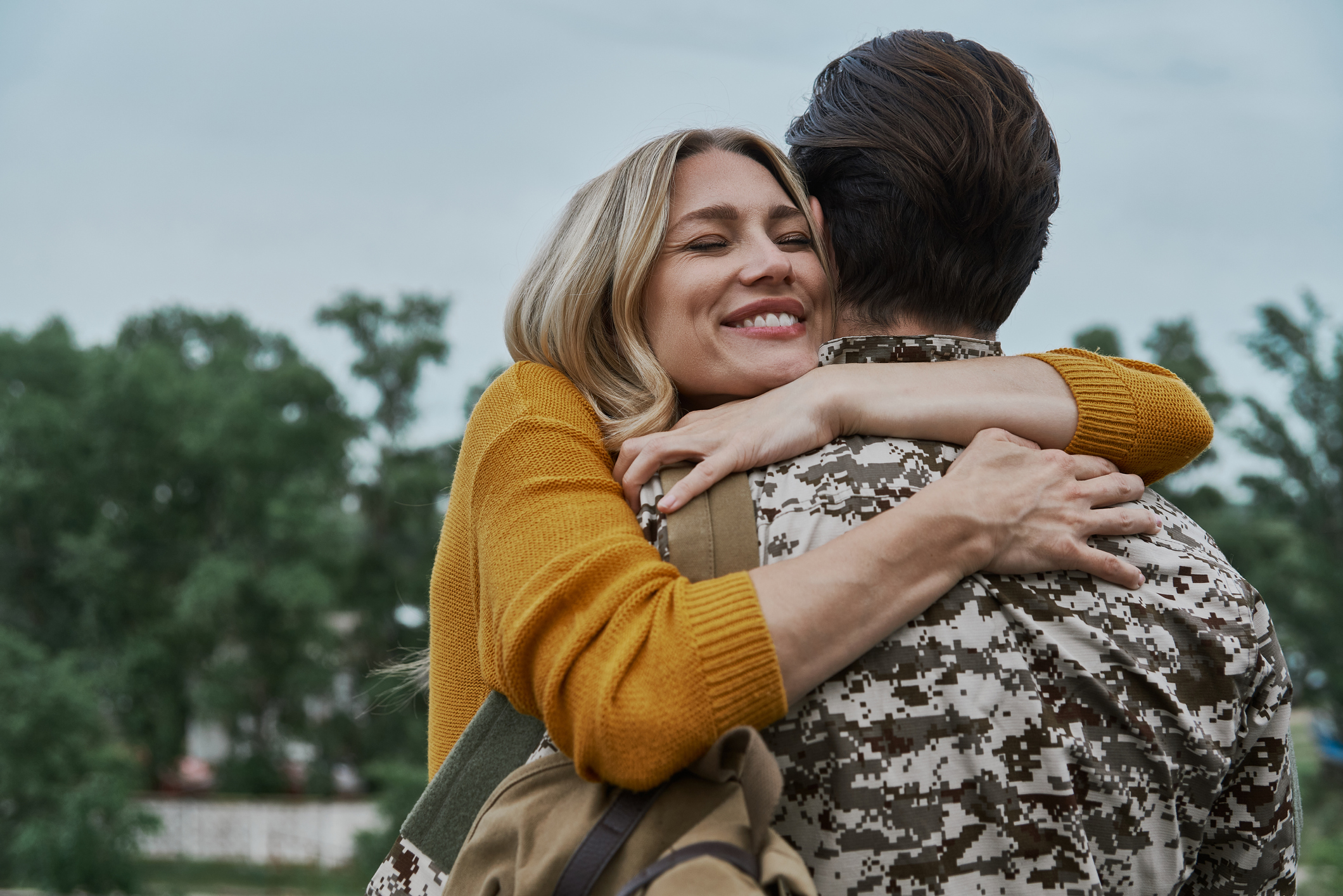 Happy woman hugging her husband after his returning home from the army. Life as a military spouse can be isolating and difficult. If you are struggling with these feelings and in need of support, therapy for military spouses in North Carolina is here to help. Learn more here.