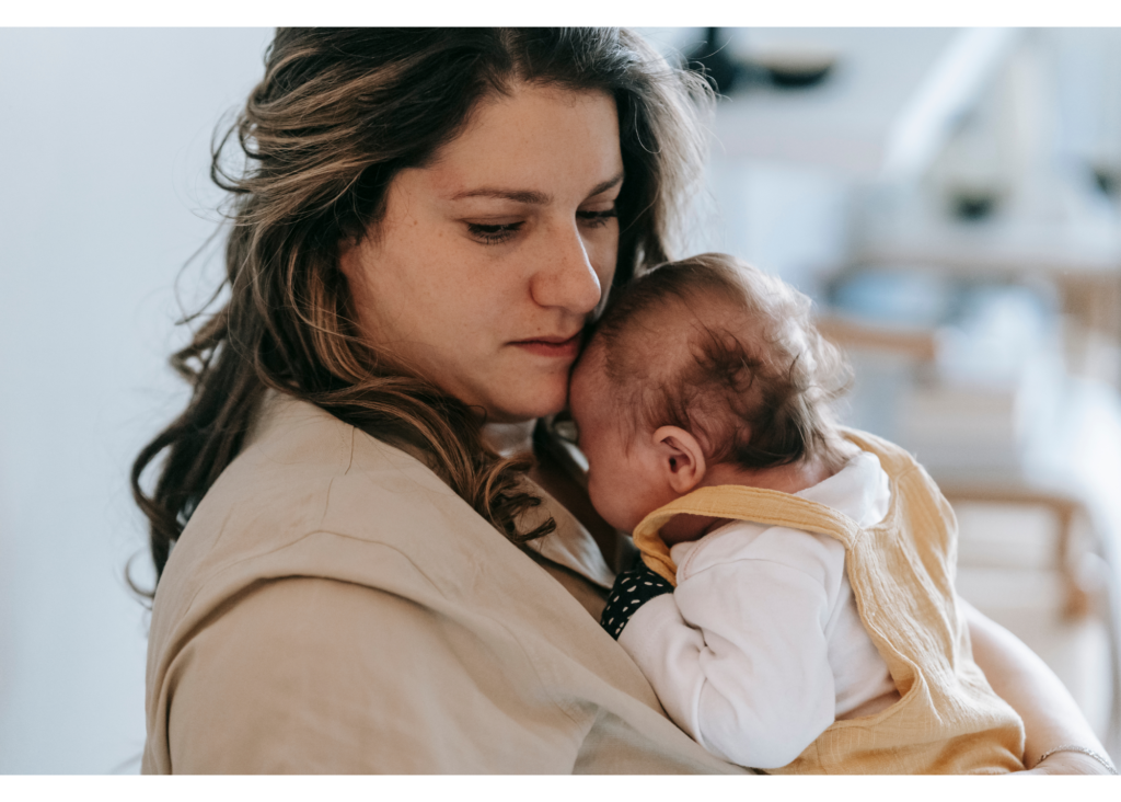 New mom holding her baby looks sad, representing postpartum depression and anxiety faced by many new mothers. It is imperative to manage post partum mental health for both you and your baby. Online therapy in North Carolina can offer the resources you need.