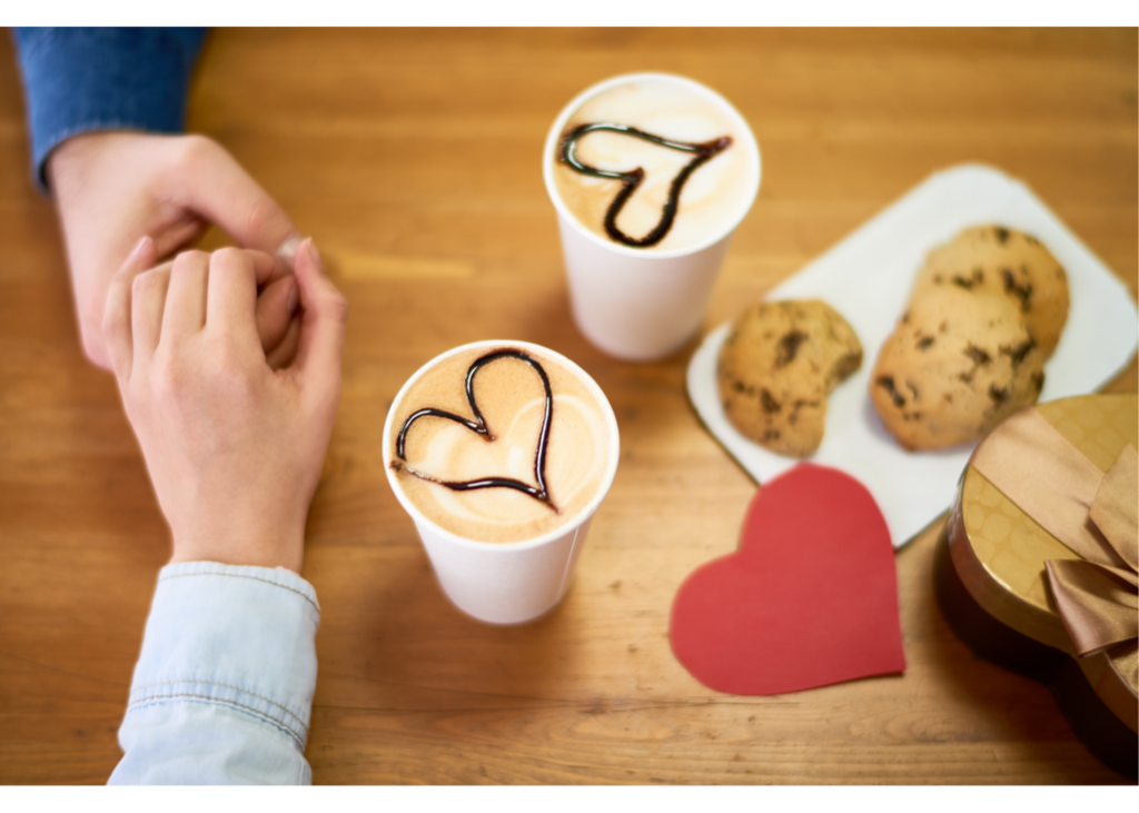 A close-up of a couple holding hands while enjoying cookies and coffee. Learn how therapy new relationships in New Burn, NC can offer support with new and established relationships. Contact an online therapist in North Carolina to learn more about online trauma therapy and other services.