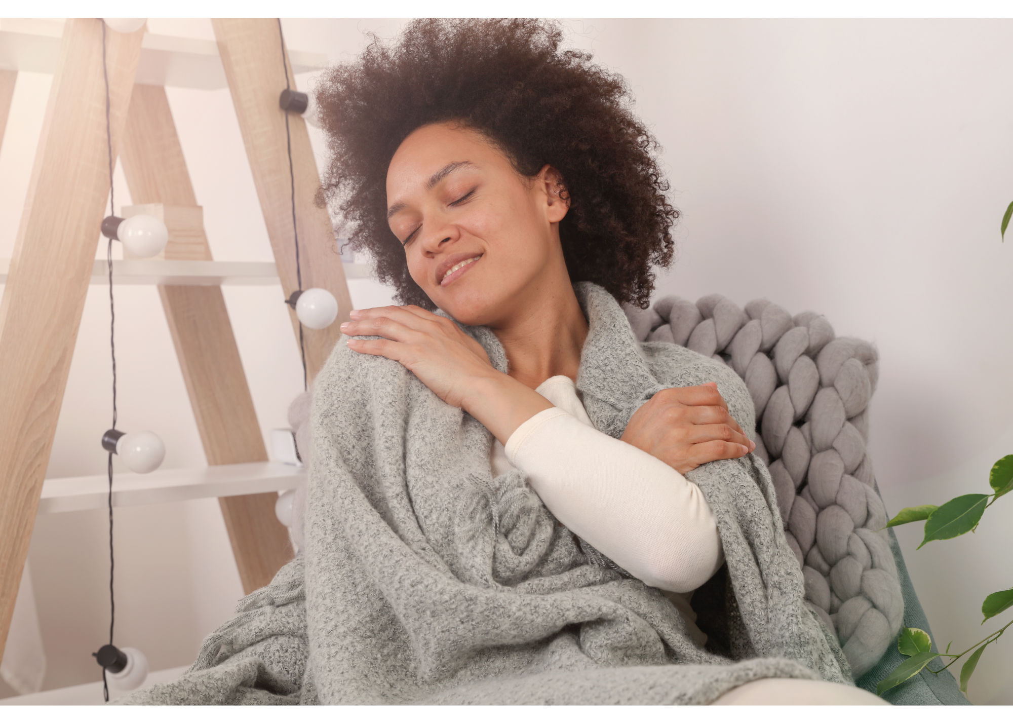 A woman smiles while wrapped in a blanket. Learn how a therapist in New Bern, NC can support you in cultivating self-care. Search “New Bern therapist” for support with mental wellness in North Carolina and more!