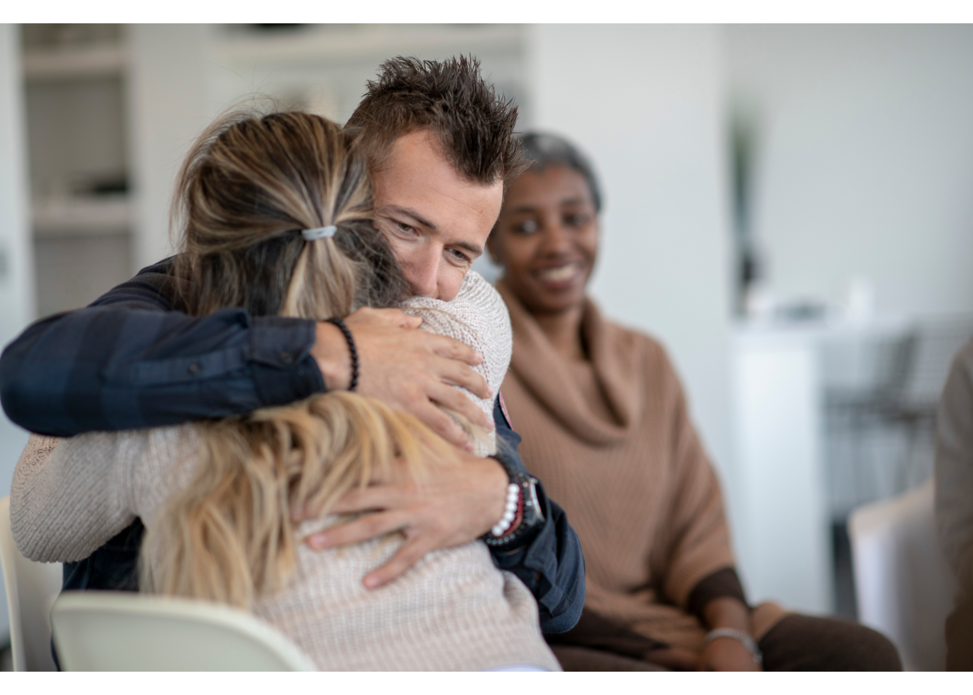 A person hugs the woman sitting next to them while sitting with a group. This could represent the support therapy for new relationships in New Bern, NC can offer with the support of a New Bern therapist. Learn more about trauma therapy in New Bern, NC and other services can offer support. 