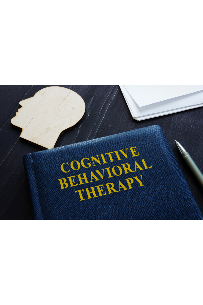 A close-up of a book titled Cognitive Behavioral Therapy on a desk. Learn more about CBT therapy in New Bern, NC, and the support a CBT therapist in North Carolina can offer from the comfort of home. An online therapist in North Carolina can support you today!