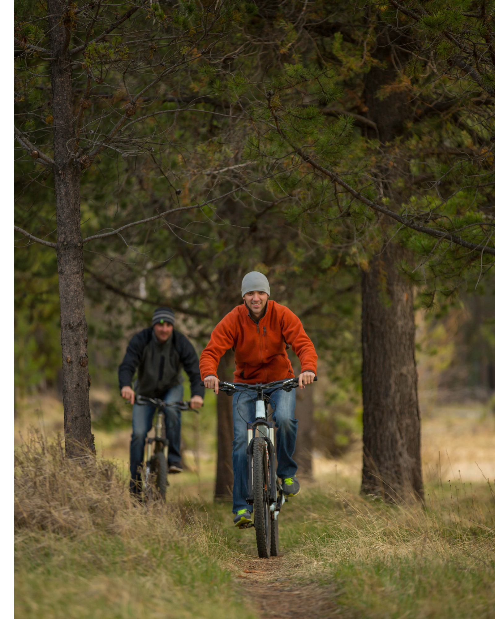 Two friends bike on a forest path as they smile. Learn how a therapist in New Bern, NC can help make new connections. Contact a young adult therapist in New Bern, NC to learn more about the benefits of online therapy in North Carolina today.