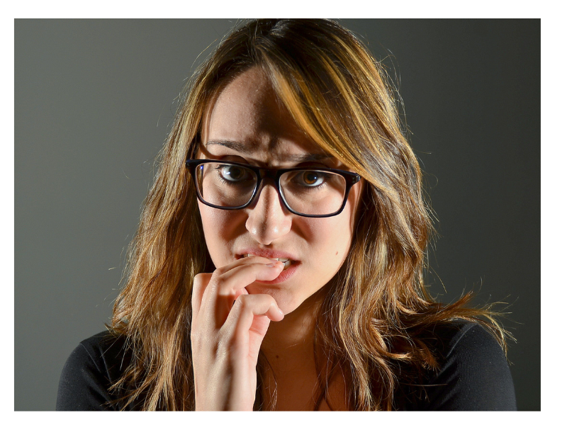 A close up of a woman biting her fingernail out of anxiety. Learn more about the support a young adult therapist in New Bern, NC can offer with overcoming anxiety. Anxiety treatment in New Bern, NC can help you by searching “therapist new bern nc” today.