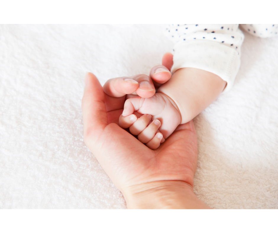 A close up of a hand holding a baby's hand. Learn how a New Bern therapist can offer support for new parents. Learn more about therapy for anxiety in New Bern, NC and other services for new parents.