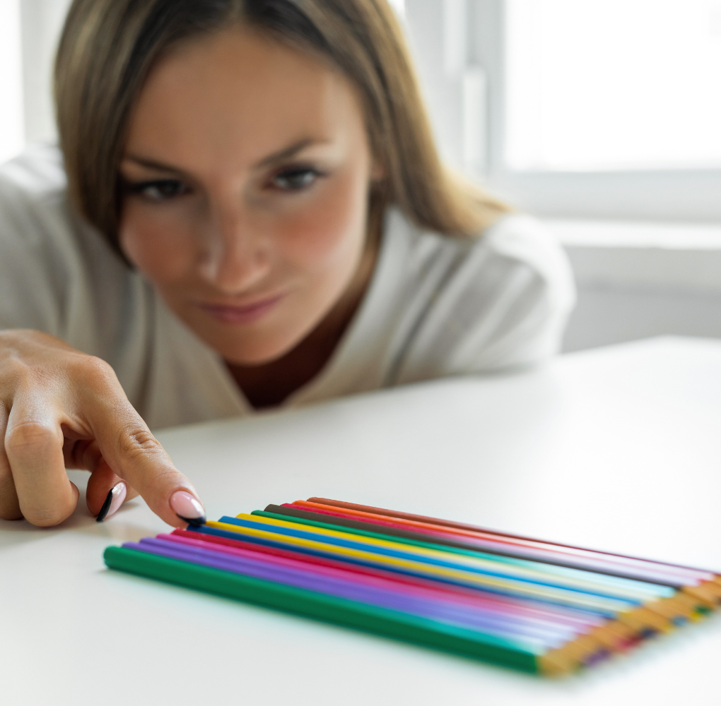 A close up of a woman moving a pencil in order with a row of other pencils. This could represent the struggles of perfectionism that therapy for anxiety and stress in New Bern, NC can address. Contact a New Bern therapist to learn more today. 
