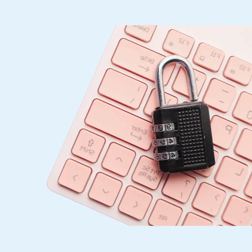 Combination padlock on a pink keyboard symbolizing cybersecurity, data protection, and online privacy.
