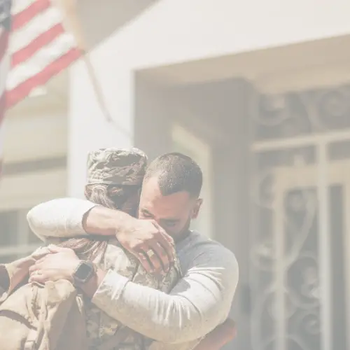 Military female hugging male partner
