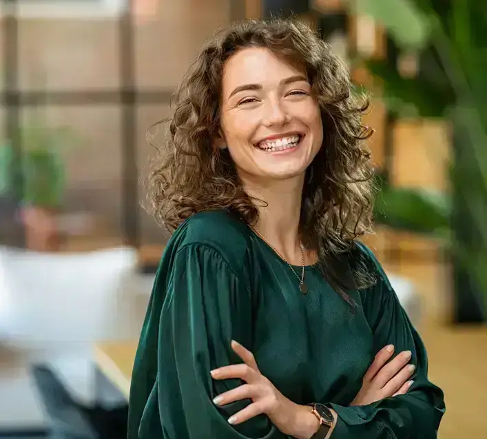 Confident young woman smiling warmly in a bright, modern setting — symbolizing emotional well-being after anxiety and stress counseling.
