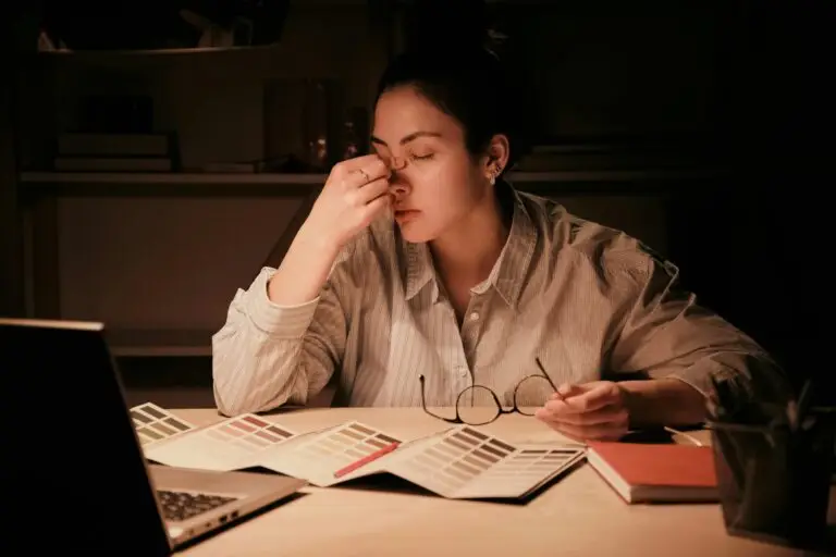 Woman sitting at a desk feeling burned out and overwhelmed by anxiety and decision fatigue