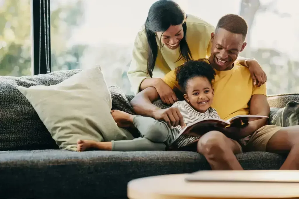 Smiling family on couch representing trust and connection with Renewed Wellness Counseling support services