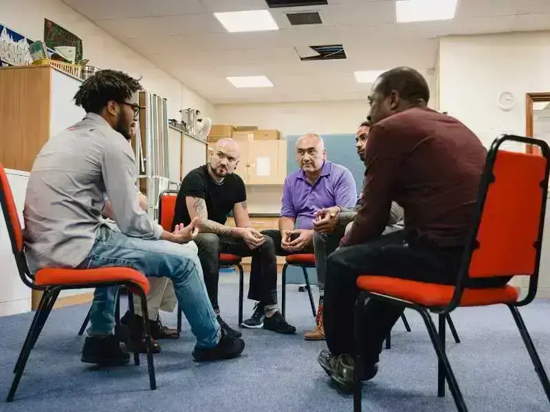 Men’s support group in discussion – community healing and mental health at Renewed Wellness Counseling.