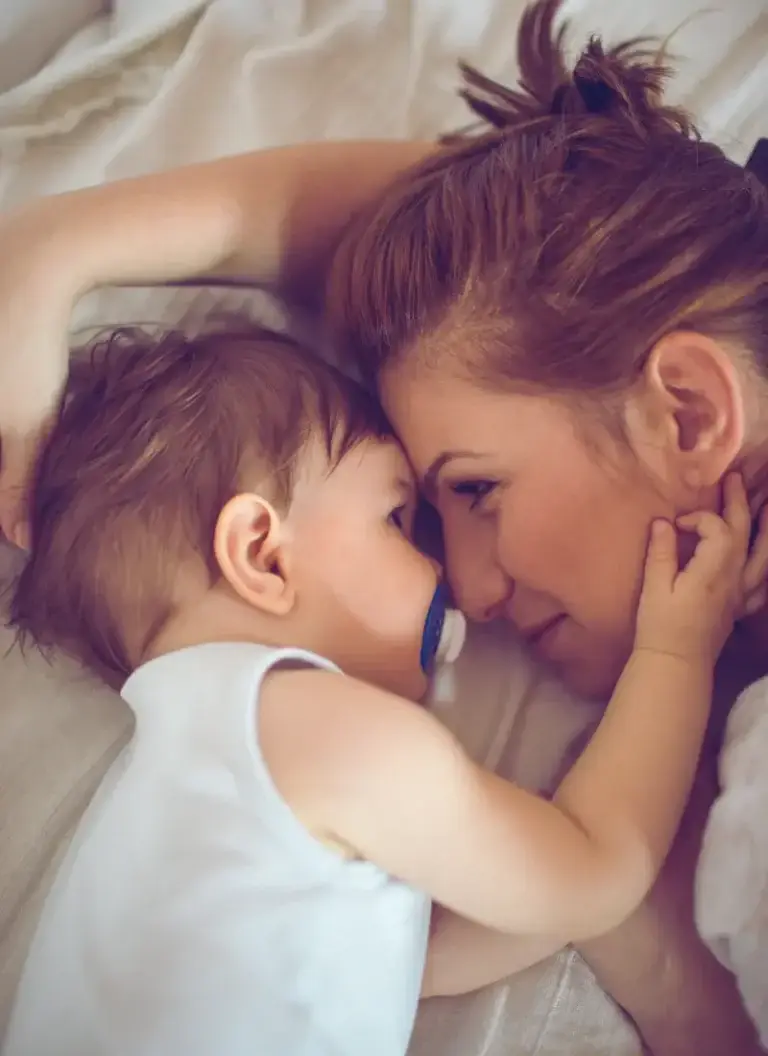 Mother and baby share a quiet, connected moment—showing the emotional bond and tenderness of early motherhood.
