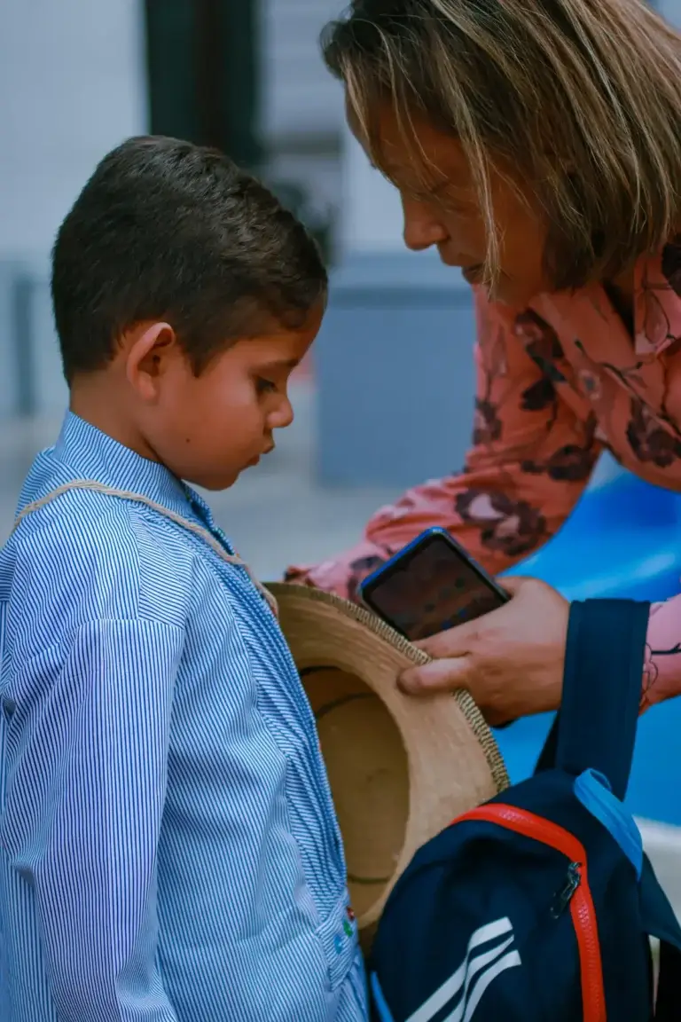 Mom kneeling to speak gently with her son before school