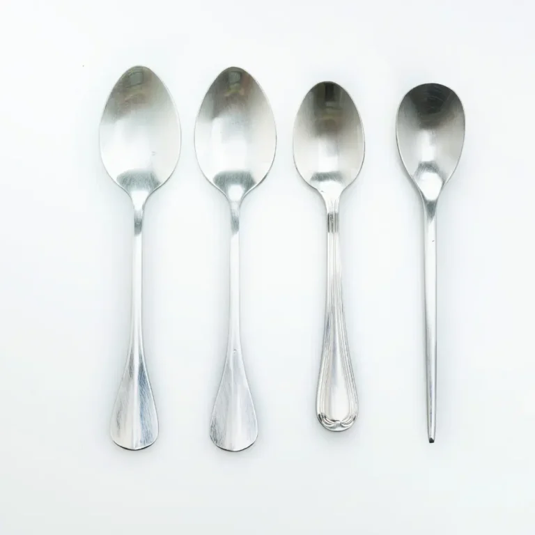 Four silver spoons on a white background representing spoon theory and energy management for people living with chronic illness — Renewed Wellness Counseling, New Bern NC