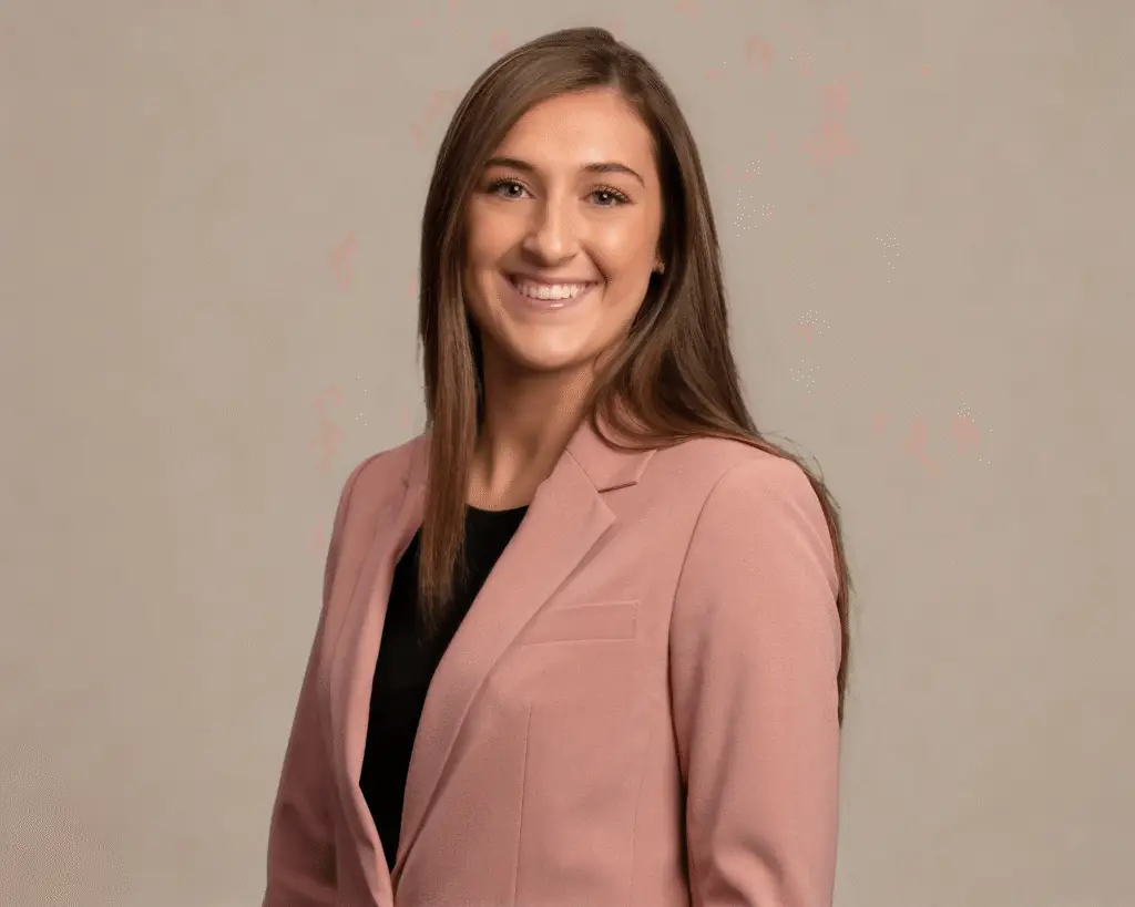 Emily Weeks, LCSWA, smiling in a pink blazer, therapist at Renewed Wellness Counseling providing virtual therapy in North Carolina and in person in New Bern, NC.