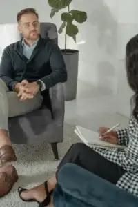 Therapist and client talking during a first therapy session, building comfort and trust in a calm office setting.