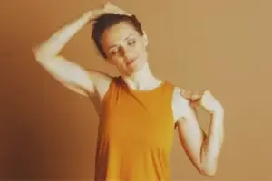 Woman gently stretching her neck as part of a calming wellness routine.