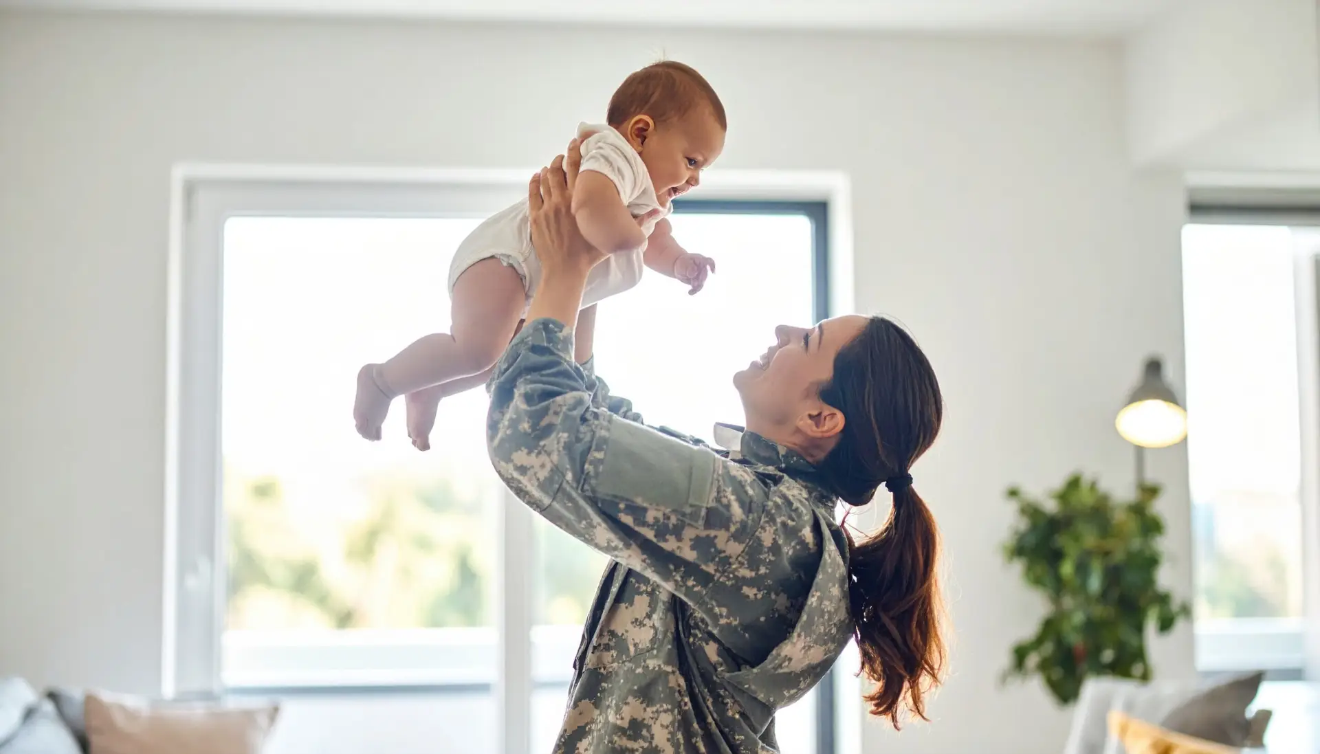 Military mom holding her baby, representing TRICARE therapy support for military families in New Bern, North Carolina and online across NC, SC, and VA with Renewed Wellness Counseling.