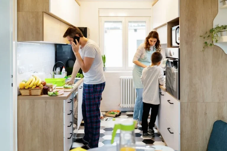 Parents managing household tasks in the kitchen with their child