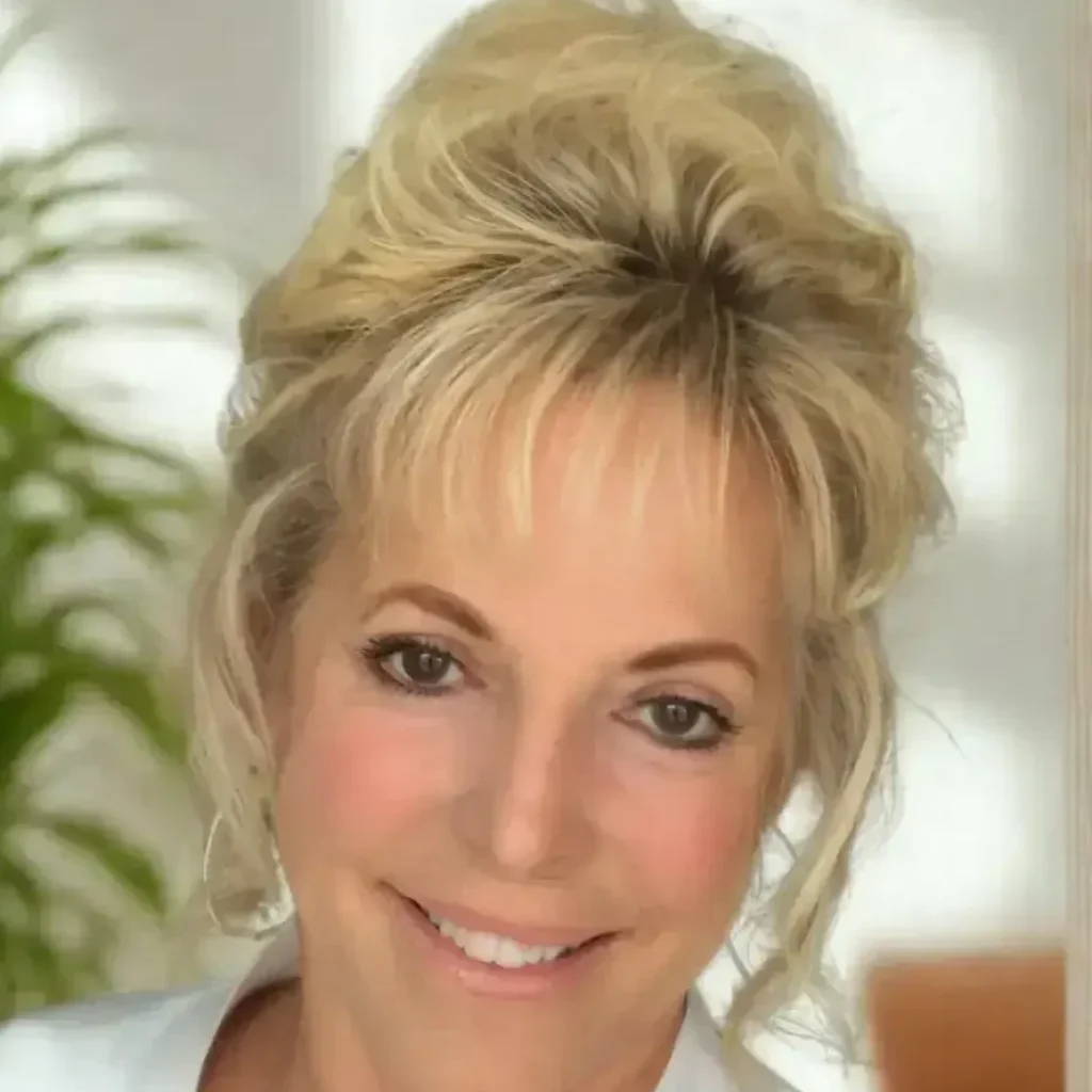 RD Headshot Rhonda Dunning, LCMHC therapist at Renewed Wellness Counseling, smiling with hair up in bright office space interior.